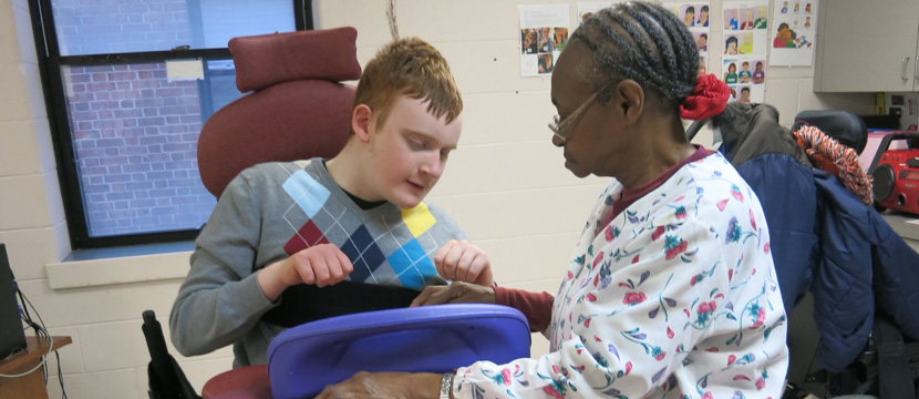 Shane is being helped by a caring staff member.